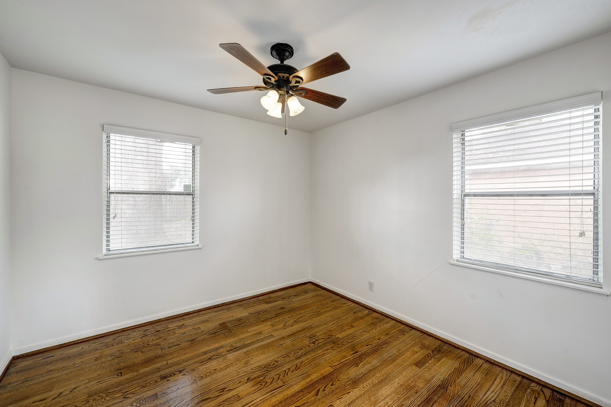 4722 Carleen Road Houston, TX 77092 - Photo 7 of 13 a view of empty room with wooden floor and fan