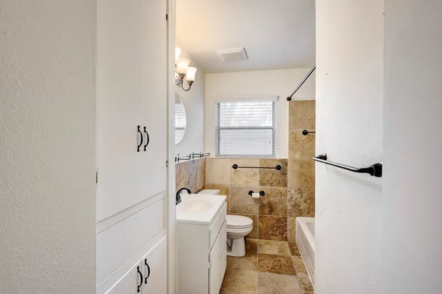 a bathroom with a granite countertop toilet sink and shower