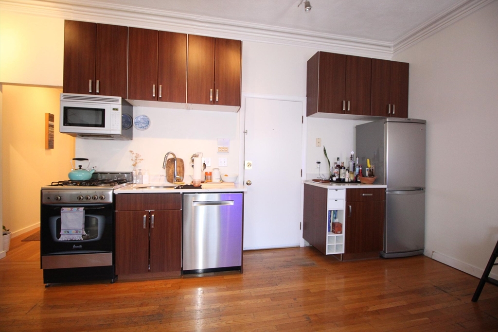 a kitchen with stainless steel appliances granite countertop a refrigerator microwave and sink