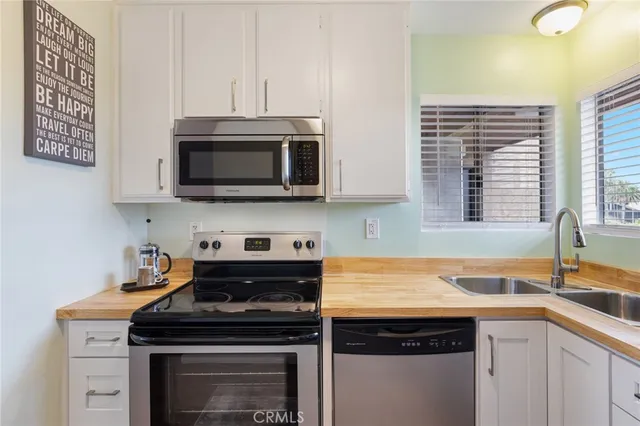 a kitchen with stainless steel appliances a stove a sink and a microwave