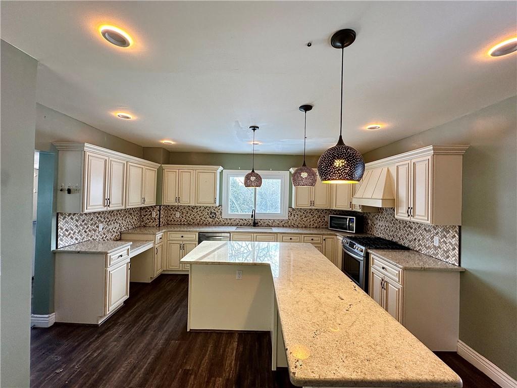 3758 Ellwood Road New Castle, PA 16101 - Photo 13 of 33 a open kitchen with kitchen island a stove a sink dishwasher a refrigerator and white cabinets with wooden floor