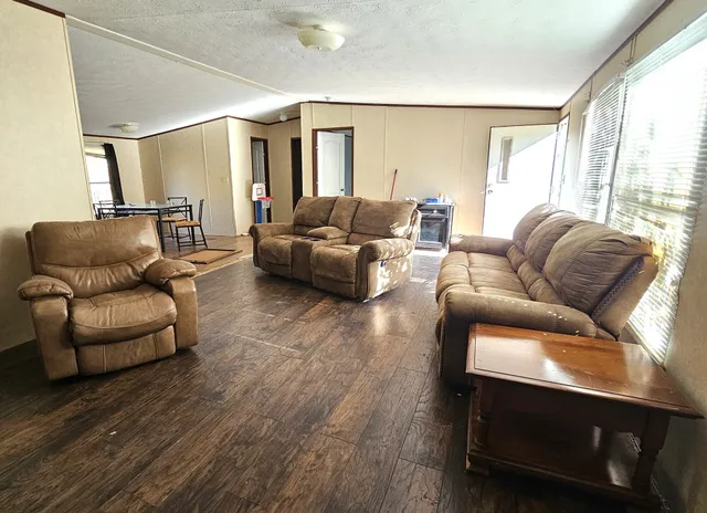 a living room with furniture and a wooden floor