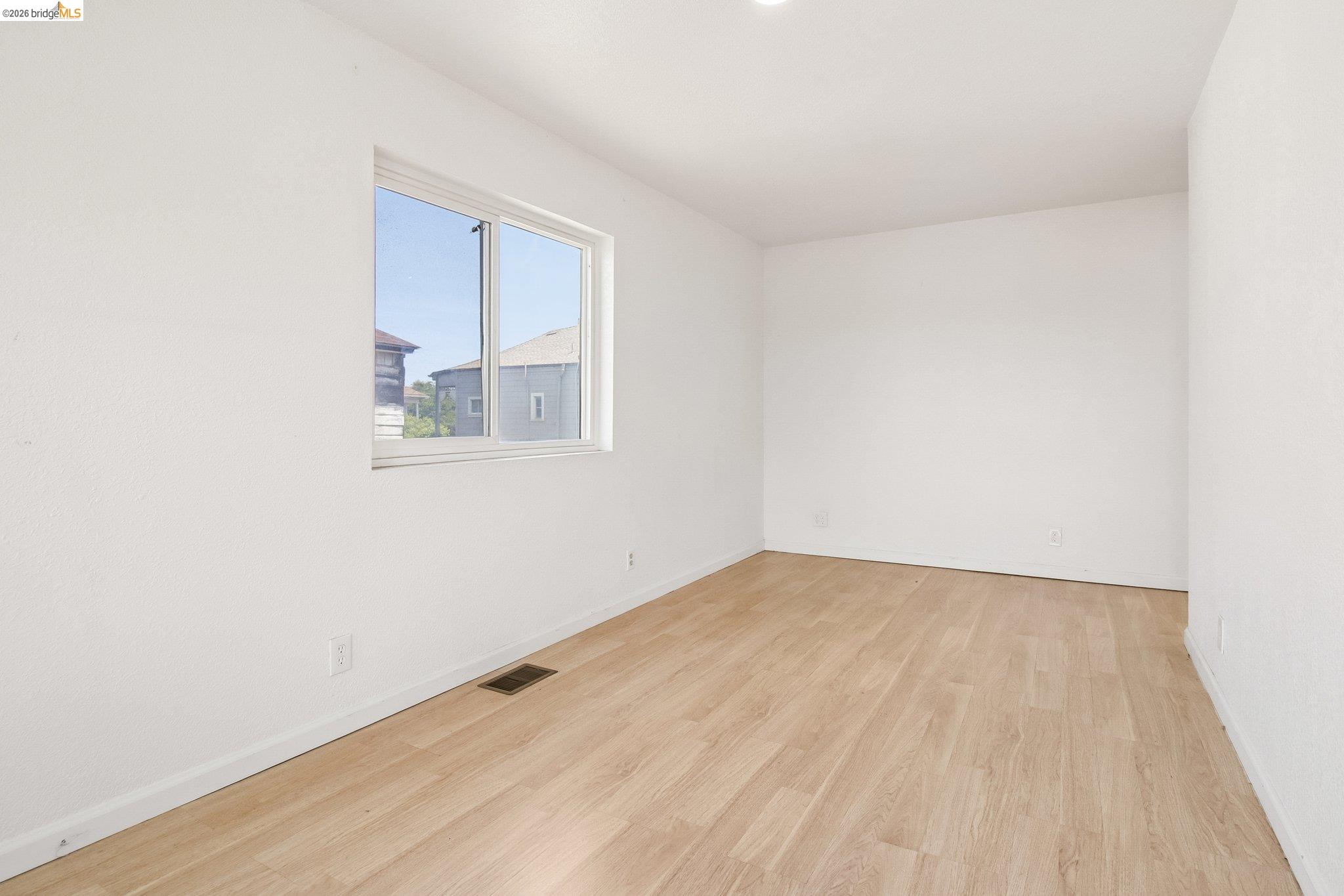 874 Pine Street Oakland, CA 94607 - Photo 16 of 39 Bright interior space featuring a window with white trim, wood-finish flooring, white baseboards, and recessed ceiling lighting