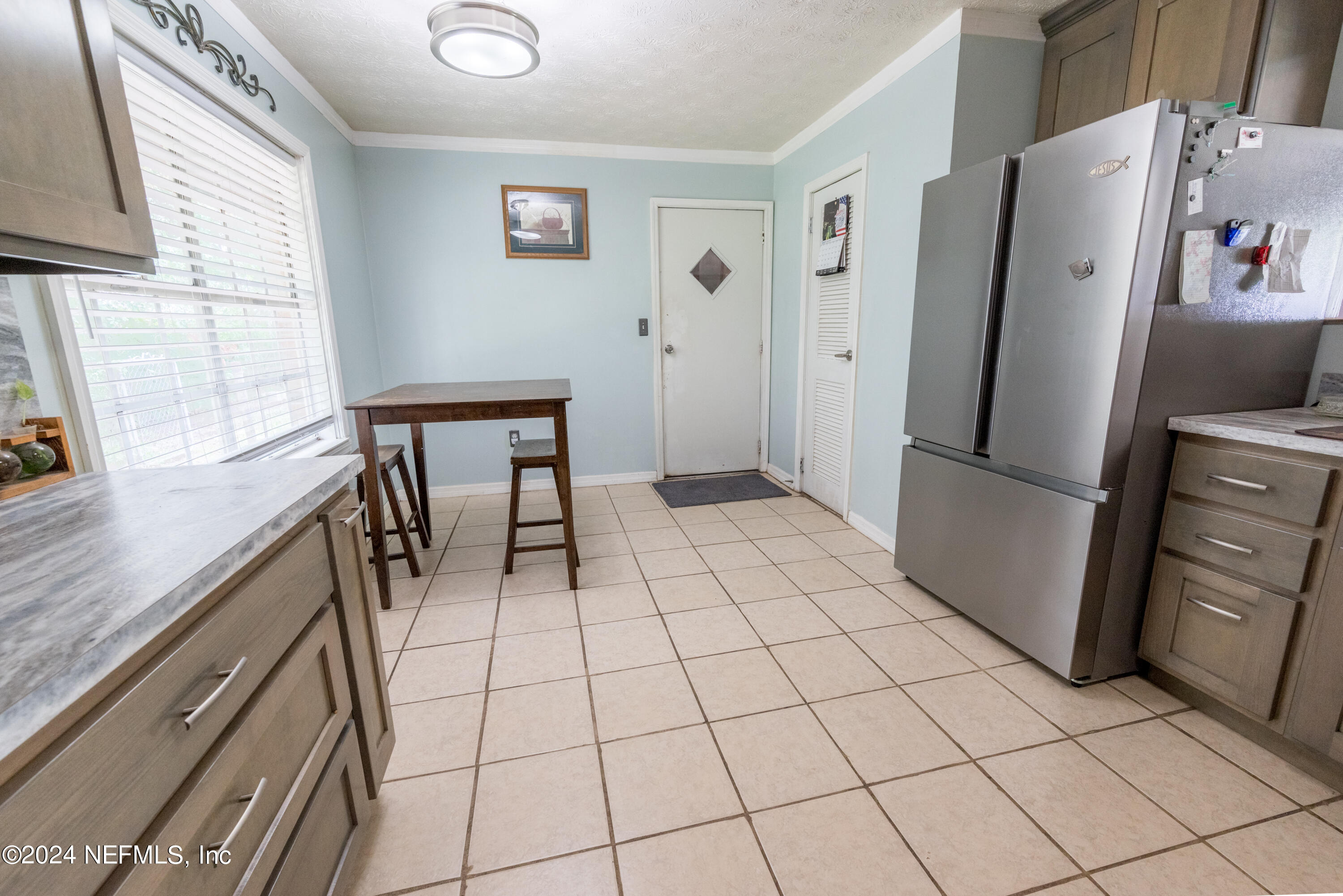 609 Collins Place Starke, FL 32091 - Photo 11 of 26 a view of a refrigerator and an empty room in wooden floor