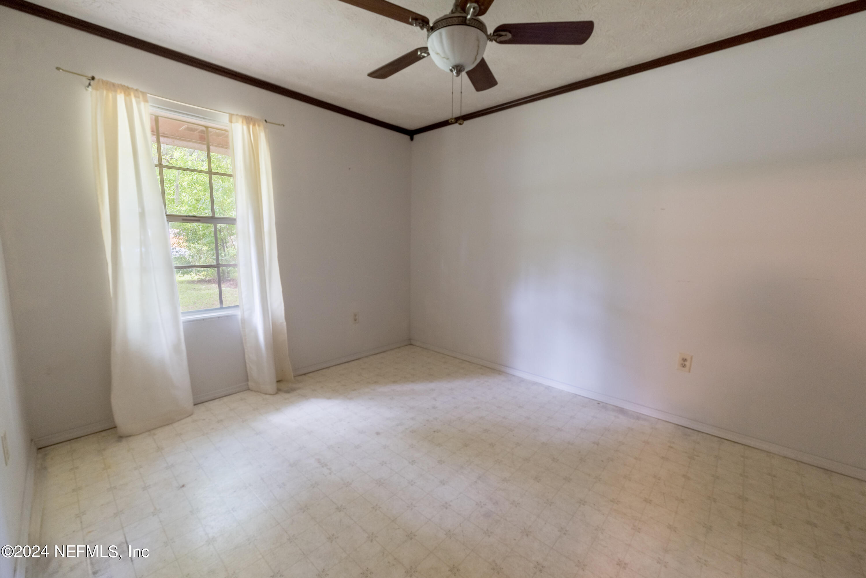 609 Collins Place Starke, FL 32091 - Photo 15 of 26 an empty room with a window and a fan