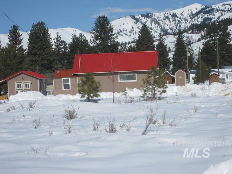 100 Prairie Road Mountain Home, ID 83647 - Photo 26 of 32 Structure with a red metal roof, light brown siding, and white window trim
