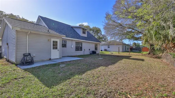 a view of a yard with a house and a large tree