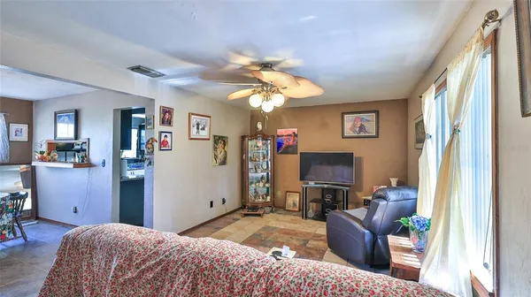 a bedroom with furniture a ceiling fan and a window