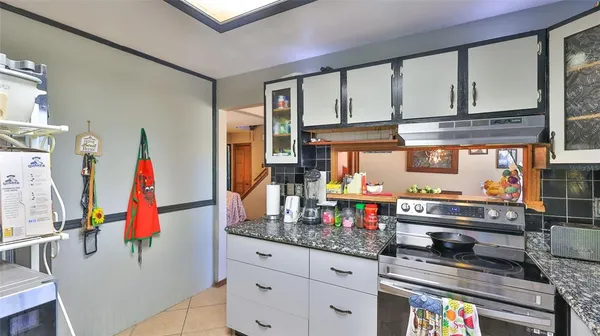 a kitchen with lots of clutter and cabinets