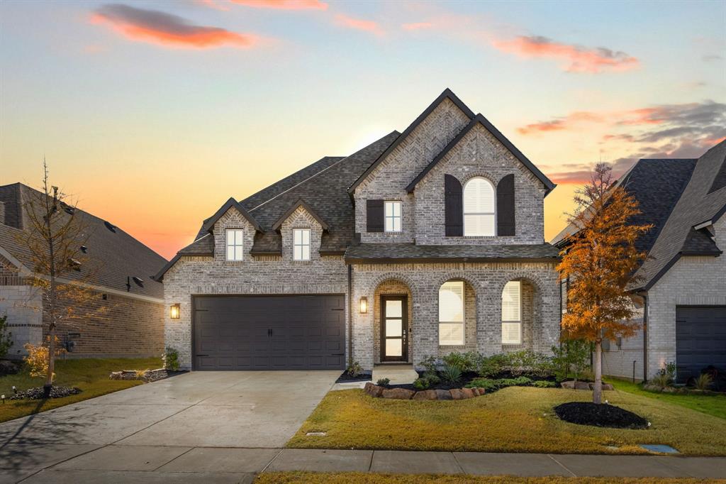 a front view of a house with yard and parking