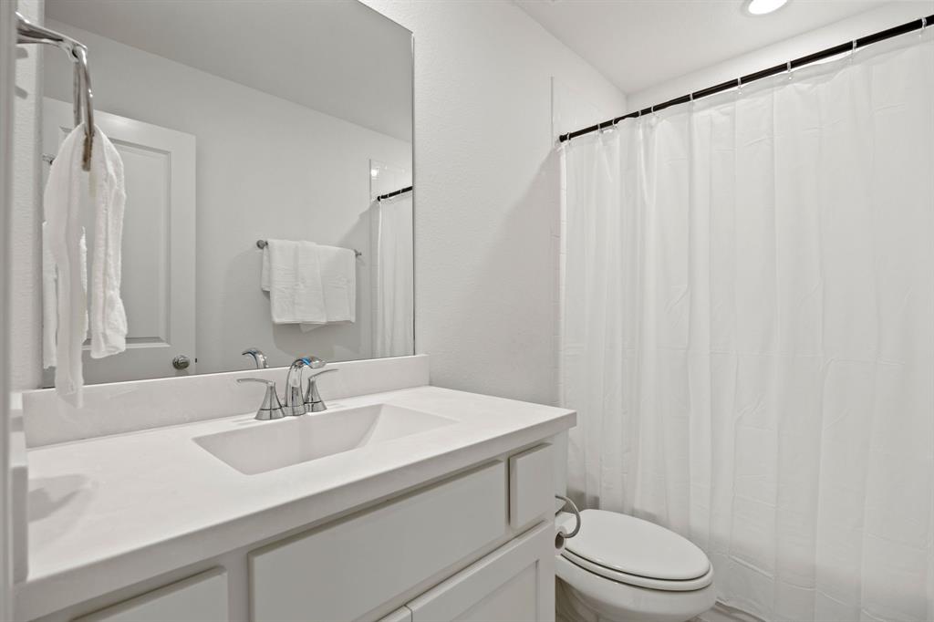 1807 Gateway Lane Van Alstyne, TX 75495 - Photo 28 of 33 a bathroom with a sink a toilet and shower curtain