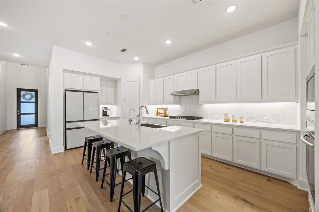 1807 Gateway Lane Van Alstyne, TX 75495 - Photo 8 of 33 a kitchen with stainless steel appliances granite countertop a white cabinets and wooden floor