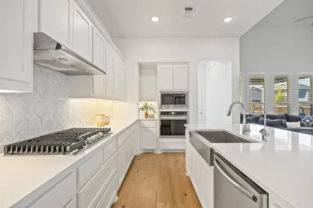 a kitchen with granite countertop a table chairs microwave and cabinets