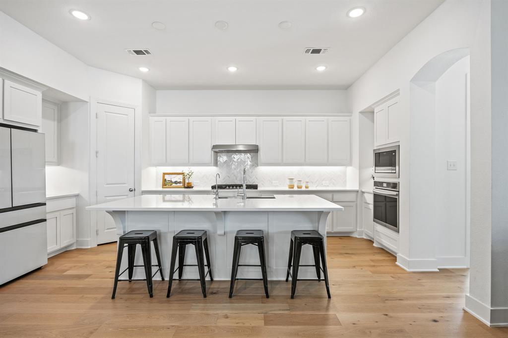 1807 Gateway Lane Van Alstyne, TX 75495 - Photo 10 of 33 a kitchen with granite countertop a table chairs microwave and cabinets