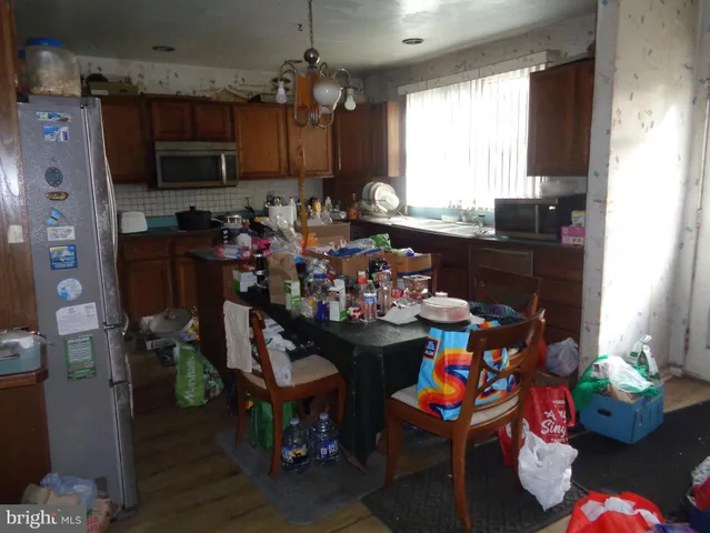 a kitchen with stainless steel appliances granite countertop a refrigerator oven a sink dishwasher and cabinets with wooden floor