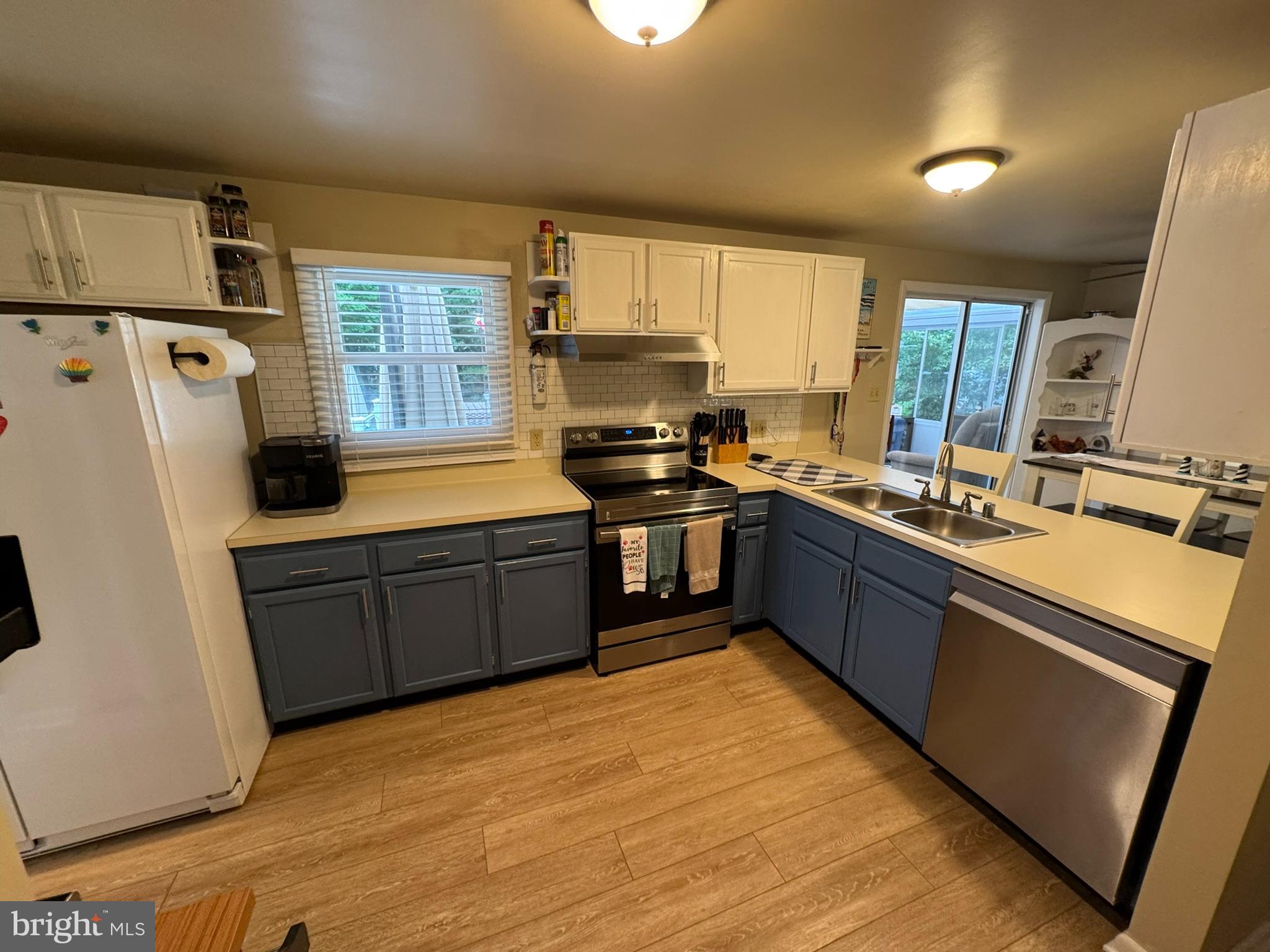 85 Pinehurst Road Ocean Pines, MD 21811 - Photo 21 of 30 a kitchen with stainless steel appliances granite countertop a refrigerator a sink dishwasher a stove with white cabinets and wooden floor