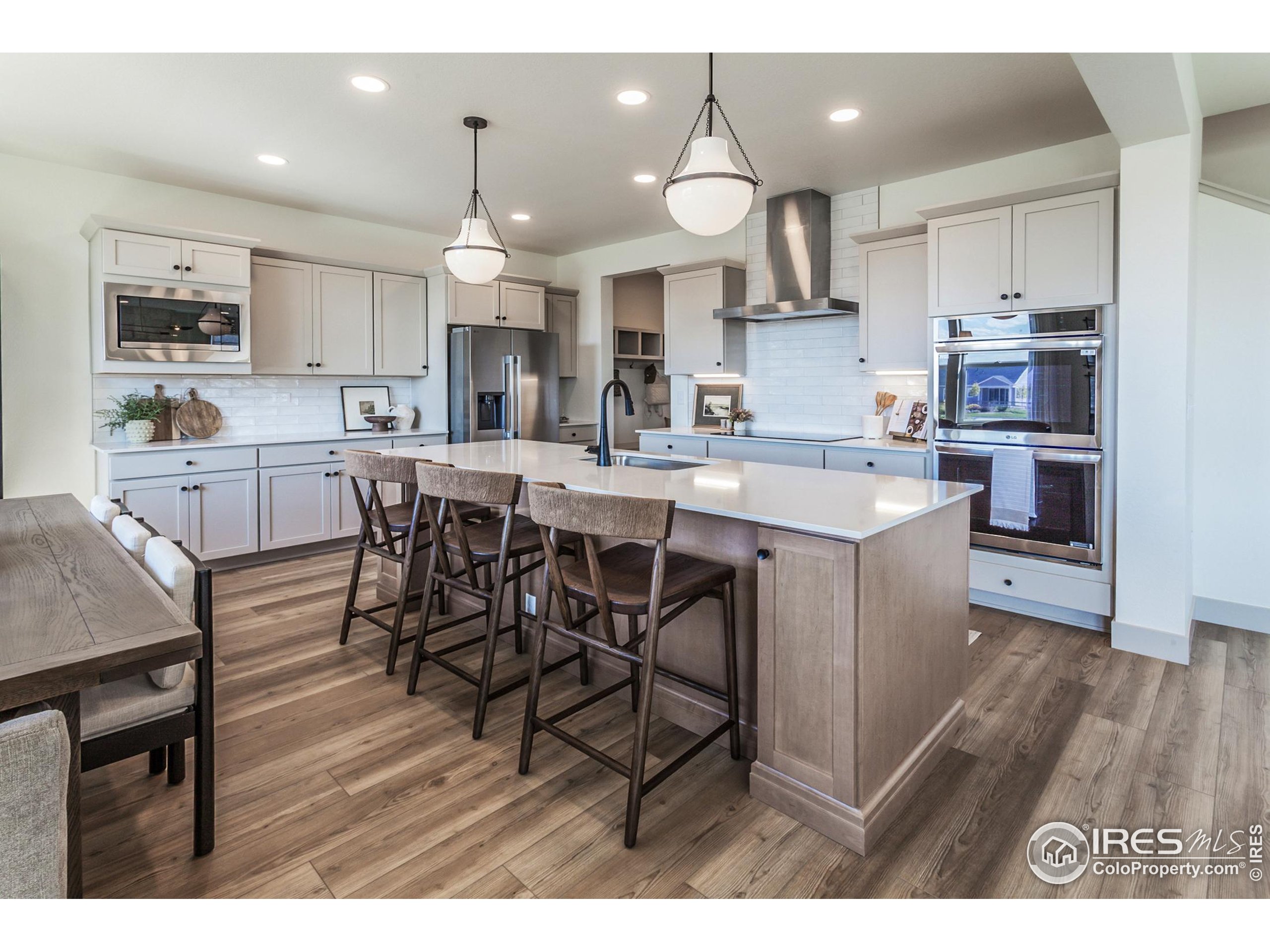6079 Red Barn Road Fort Collins, CO 80528 - Photo 11 of 41 a kitchen with stainless steel appliances a dining table chairs stove refrigerator and cabinets