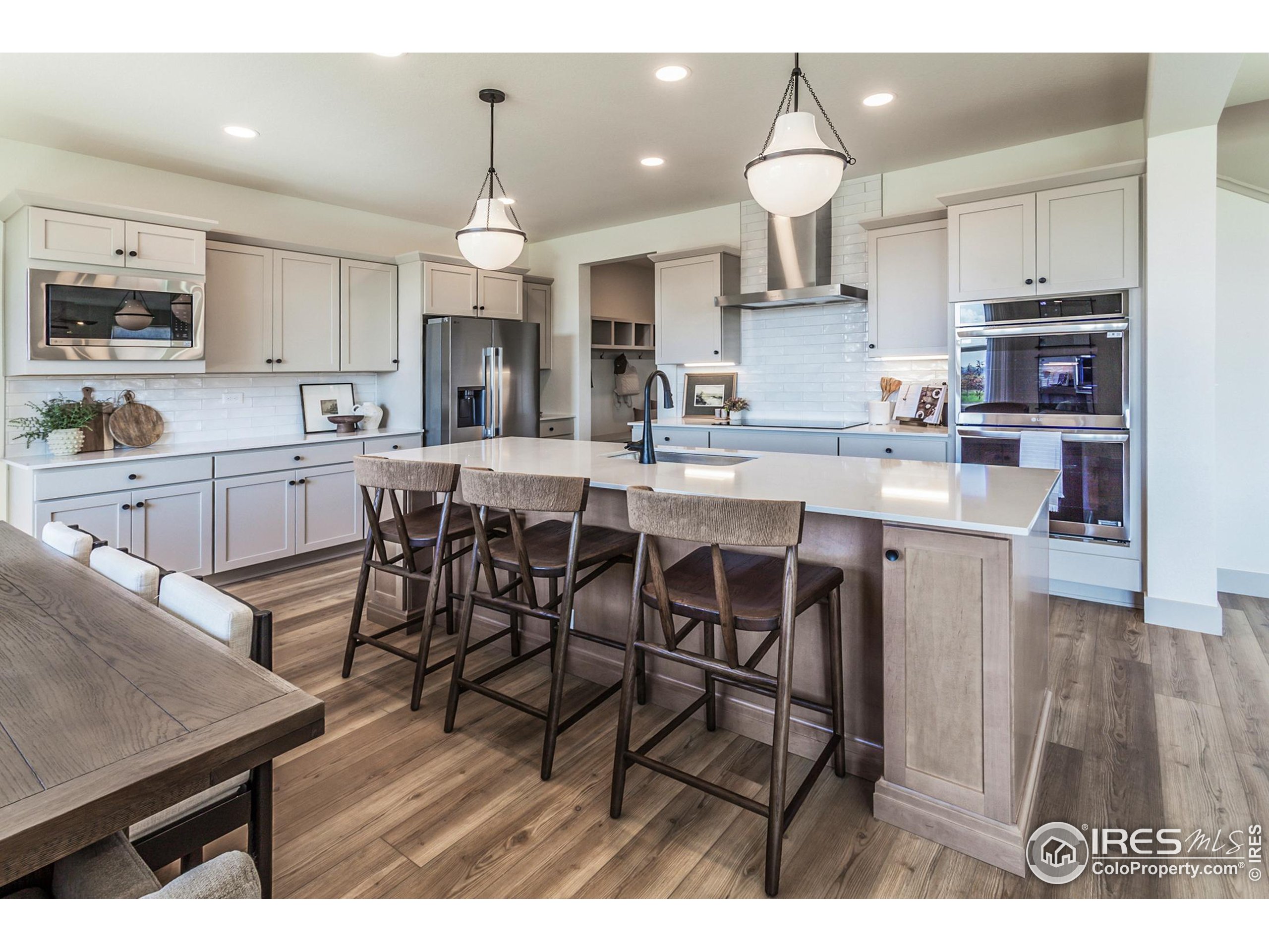 6079 Red Barn Road Fort Collins, CO 80528 - Photo 15 of 41 a large kitchen with cabinets wooden floor white stainless steel appliances and chairs