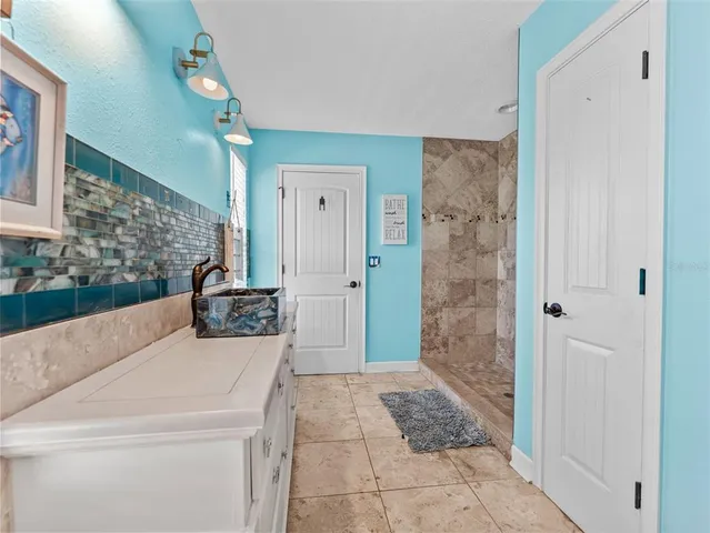 a bathroom with a tub shower vanity and a sink
