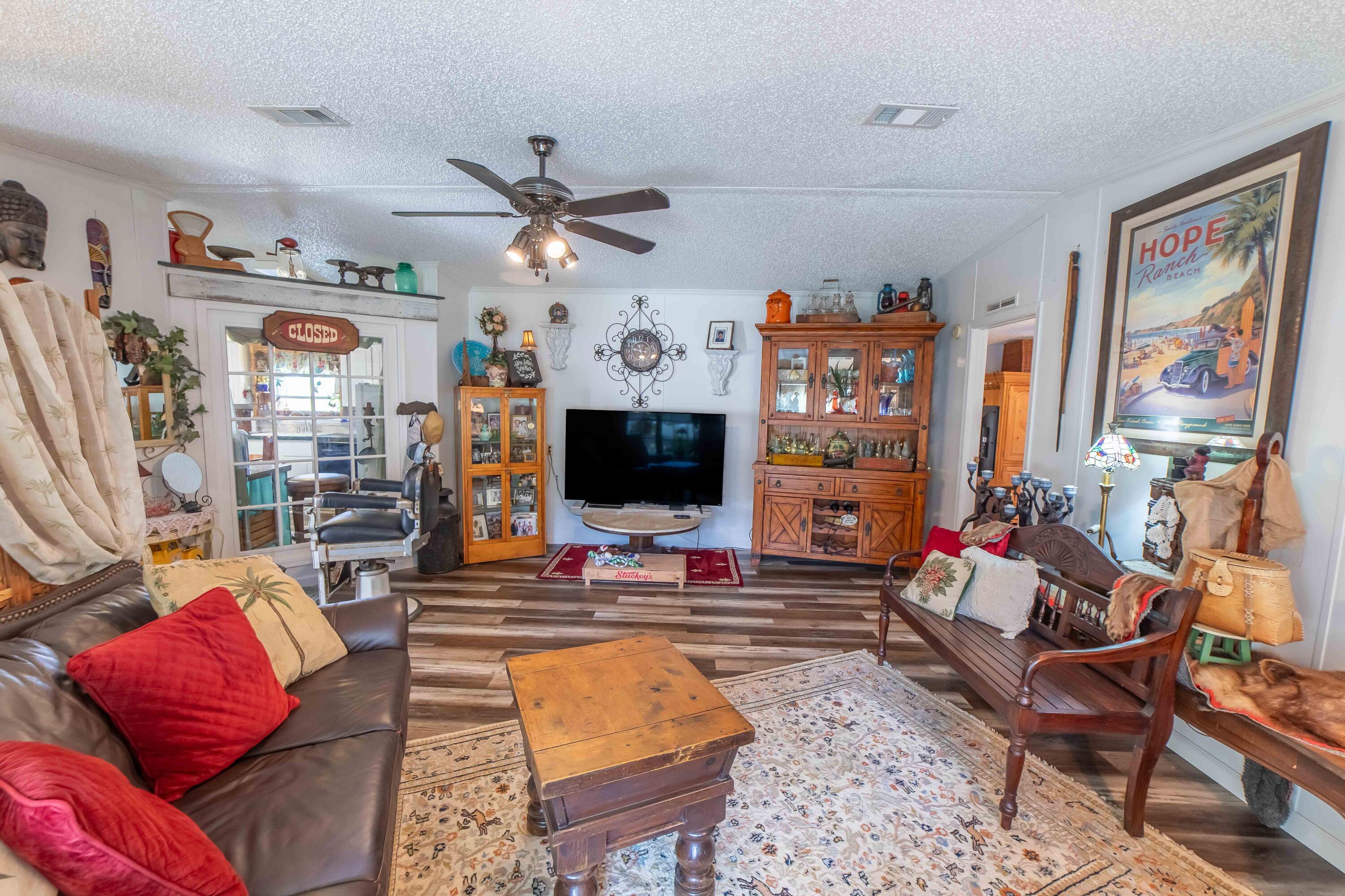 12302 Highway 441 Okeechobee, FL 34974 - Photo 15 of 63 a living room with furniture kitchen view and a flat screen tv