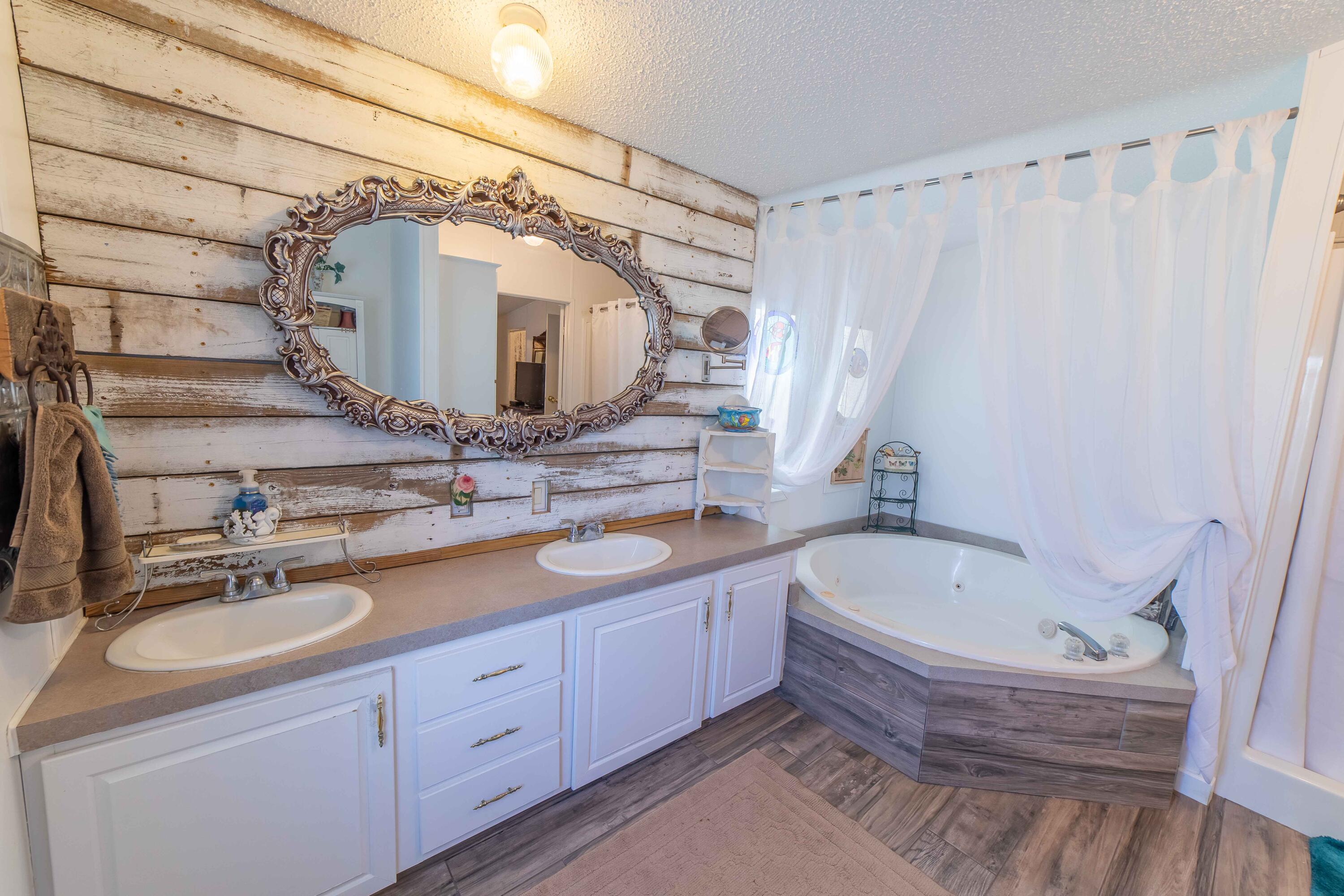 12302 Highway 441 Okeechobee, FL 34974 - Photo 28 of 63 a bathroom with a tub sink and mirror