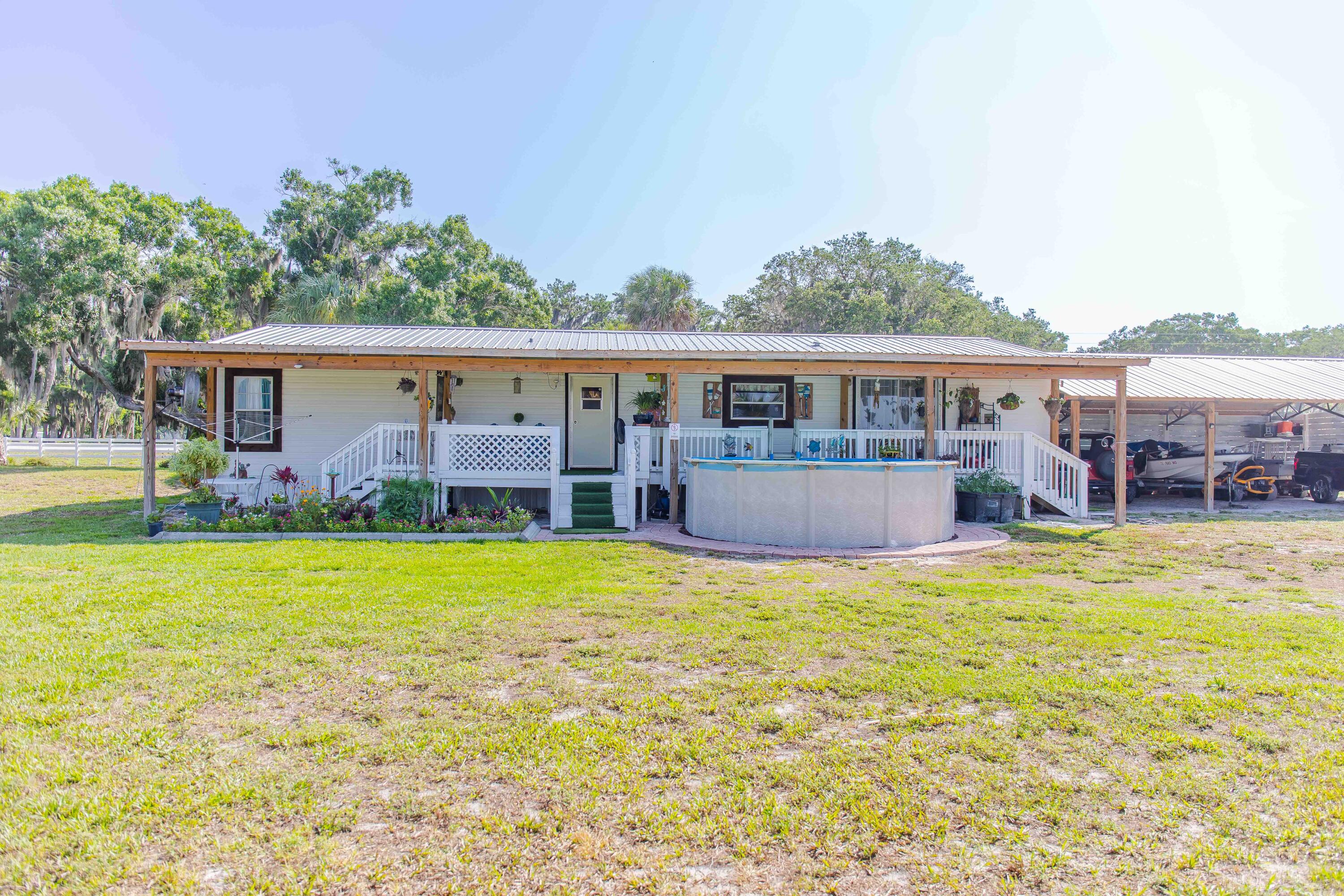 12302 Highway 441 Okeechobee, FL 34974 - Photo 48 of 63 a view of a house with a patio and a yard