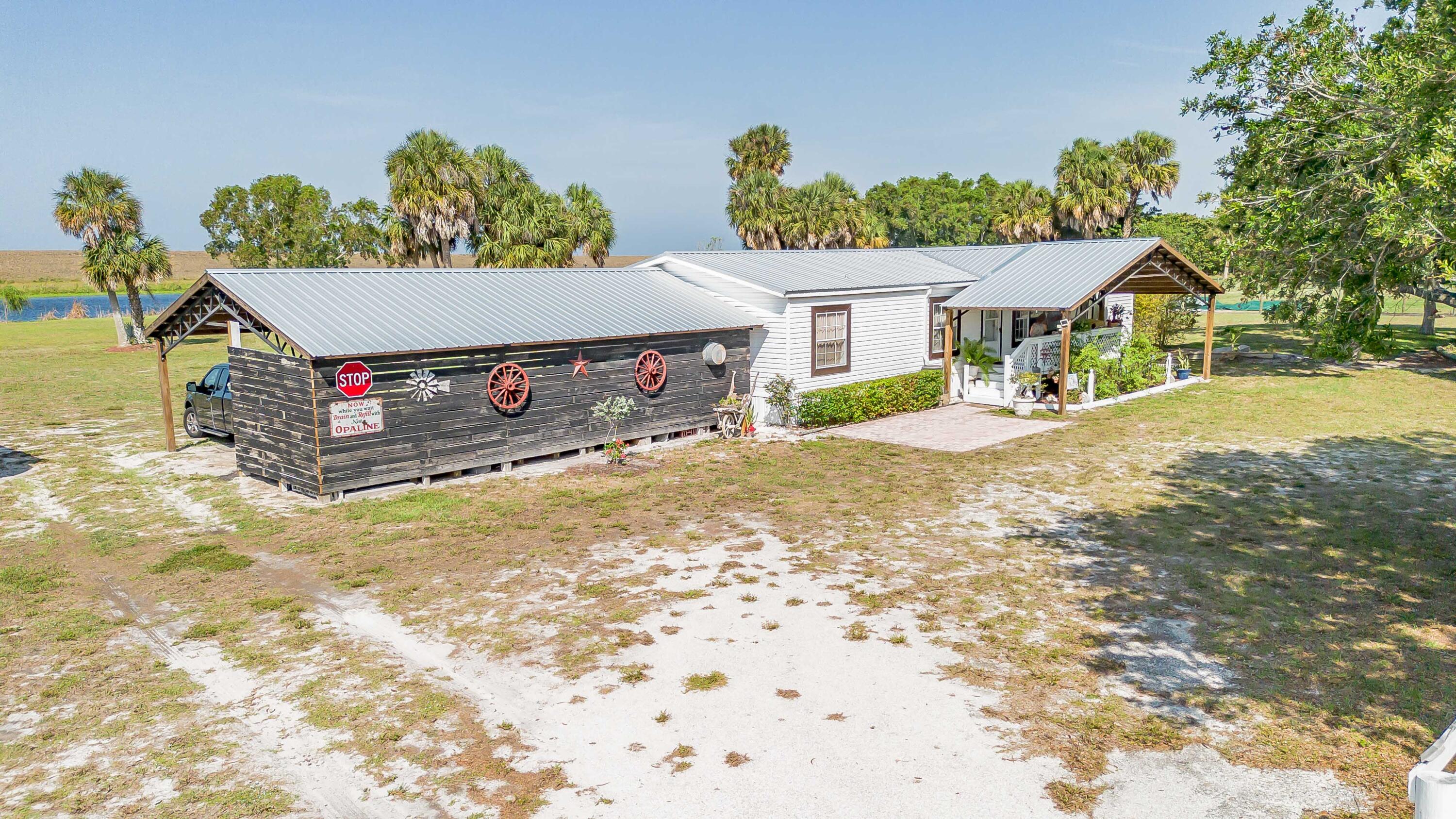 12302 Highway 441 Okeechobee, FL 34974 - Photo 58 of 63 a front view of a house with a yard and garage
