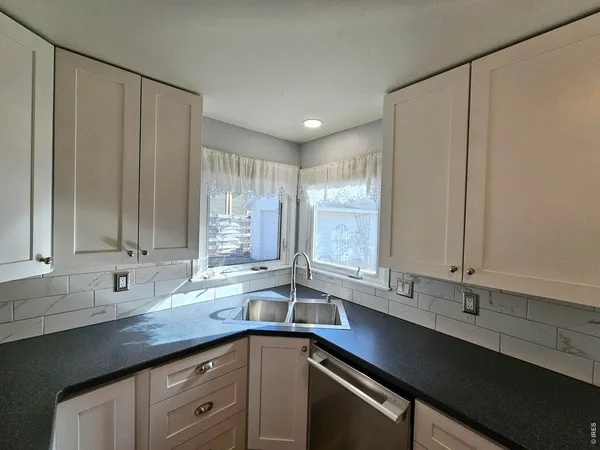 a view of an empty room with closet and a window