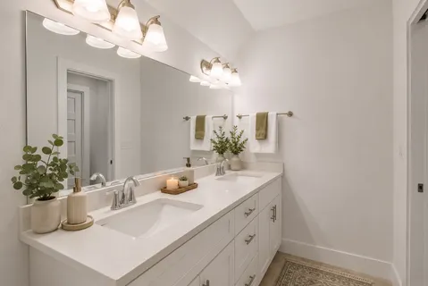 a bathroom with a sink a toilet and a large mirror