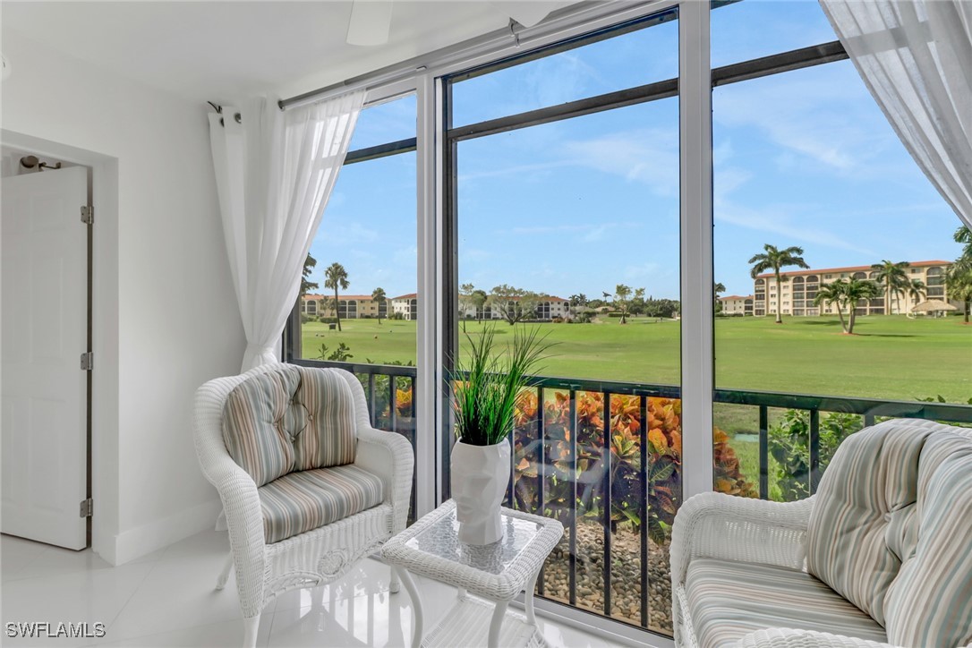9 High Point Circle North, Unit 102 Naples, FL 34103 - Photo 12 of 48 a living room with couch and a floor to ceiling window