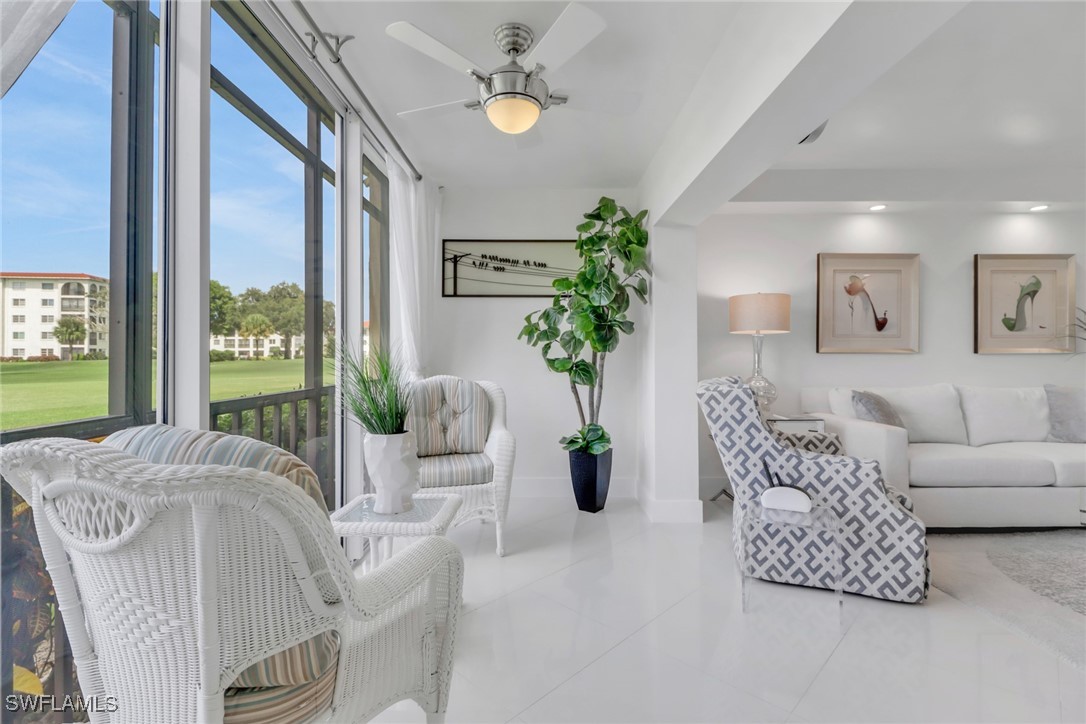 9 High Point Circle North, Unit 102 Naples, FL 34103 - Photo 13 of 48 a living room with furniture and a large window