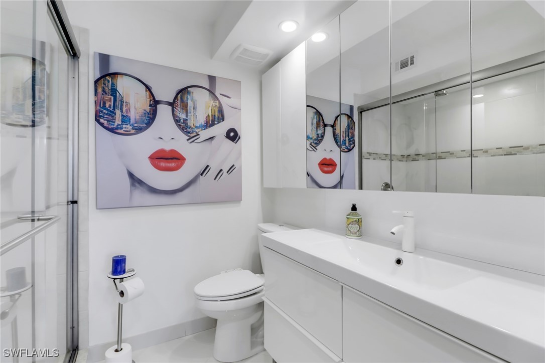 9 High Point Circle North, Unit 102 Naples, FL 34103 - Photo 17 of 48 a bathroom with a sink a toilet and a bathtub