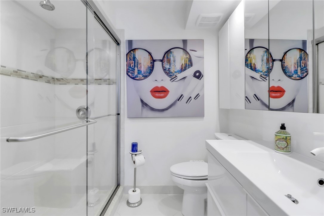 9 High Point Circle North, Unit 102 Naples, FL 34103 - Photo 18 of 48 a bathroom with a toilet and a shower