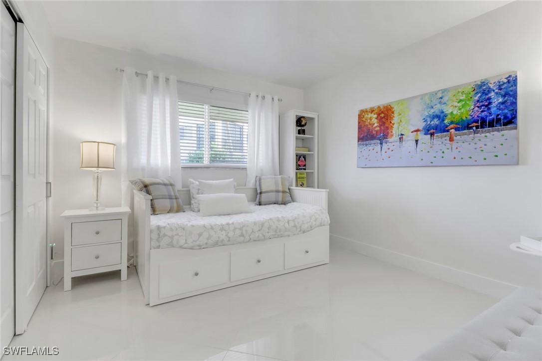9 High Point Circle North, Unit 102 Naples, FL 34103 - Photo 20 of 48 a spacious bedroom with a bed and a window