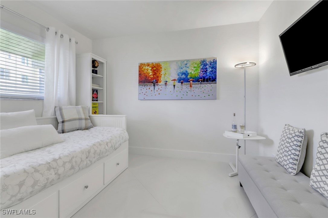 9 High Point Circle North, Unit 102 Naples, FL 34103 - Photo 21 of 48 a bedroom with a bed and a flat screen tv