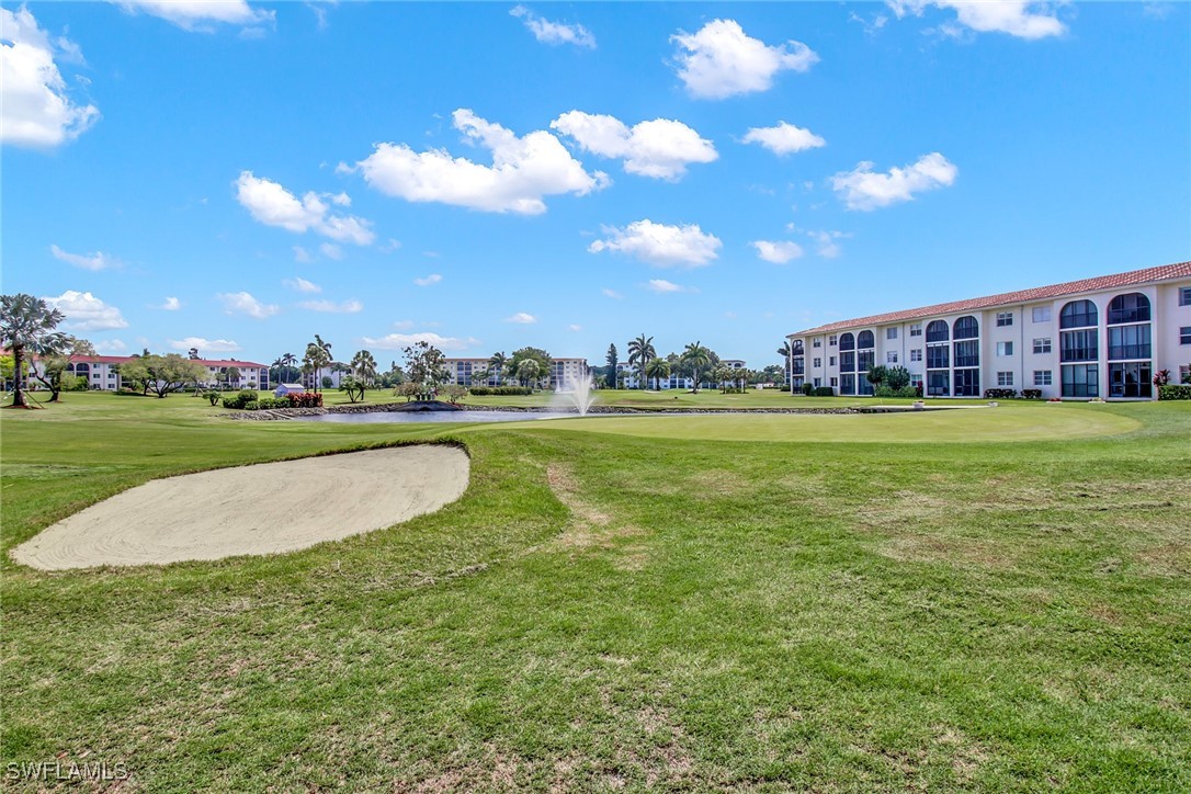 9 High Point Circle North, Unit 102 Naples, FL 34103 - Photo 29 of 48 a view of a swimming pool and a yard