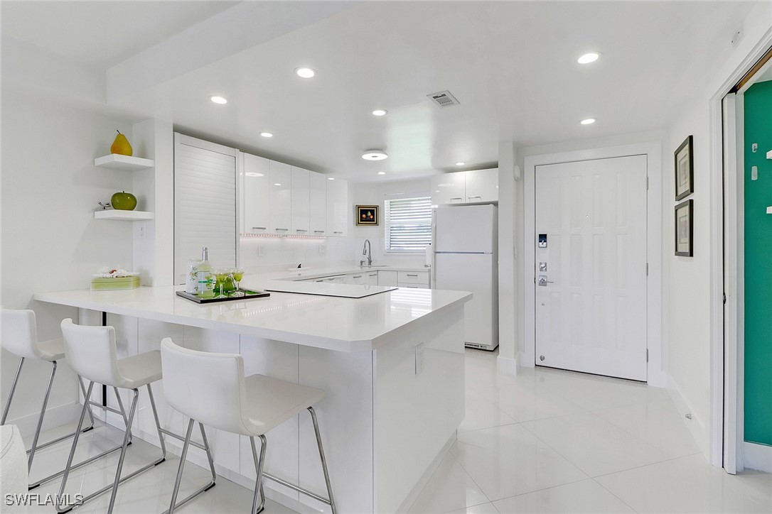 9 High Point Circle North, Unit 102 Naples, FL 34103 - Photo 3 of 48 a kitchen with a sink cabinets and stainless steel appliances