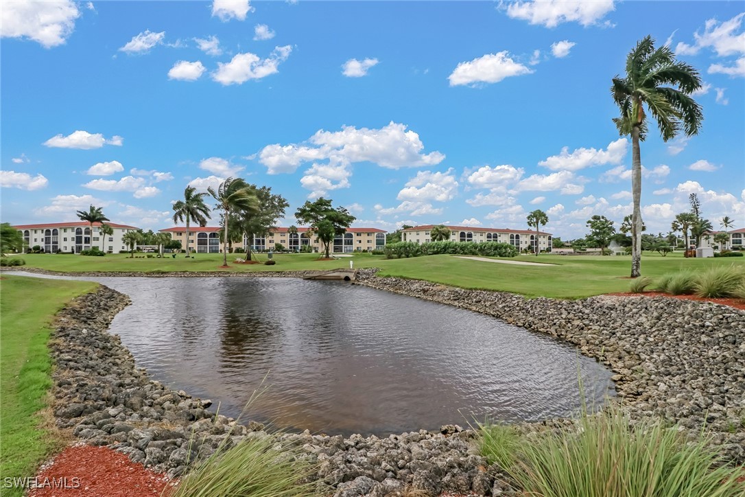 9 High Point Circle North, Unit 102 Naples, FL 34103 - Photo 36 of 48 a view of a lake with houses in the background