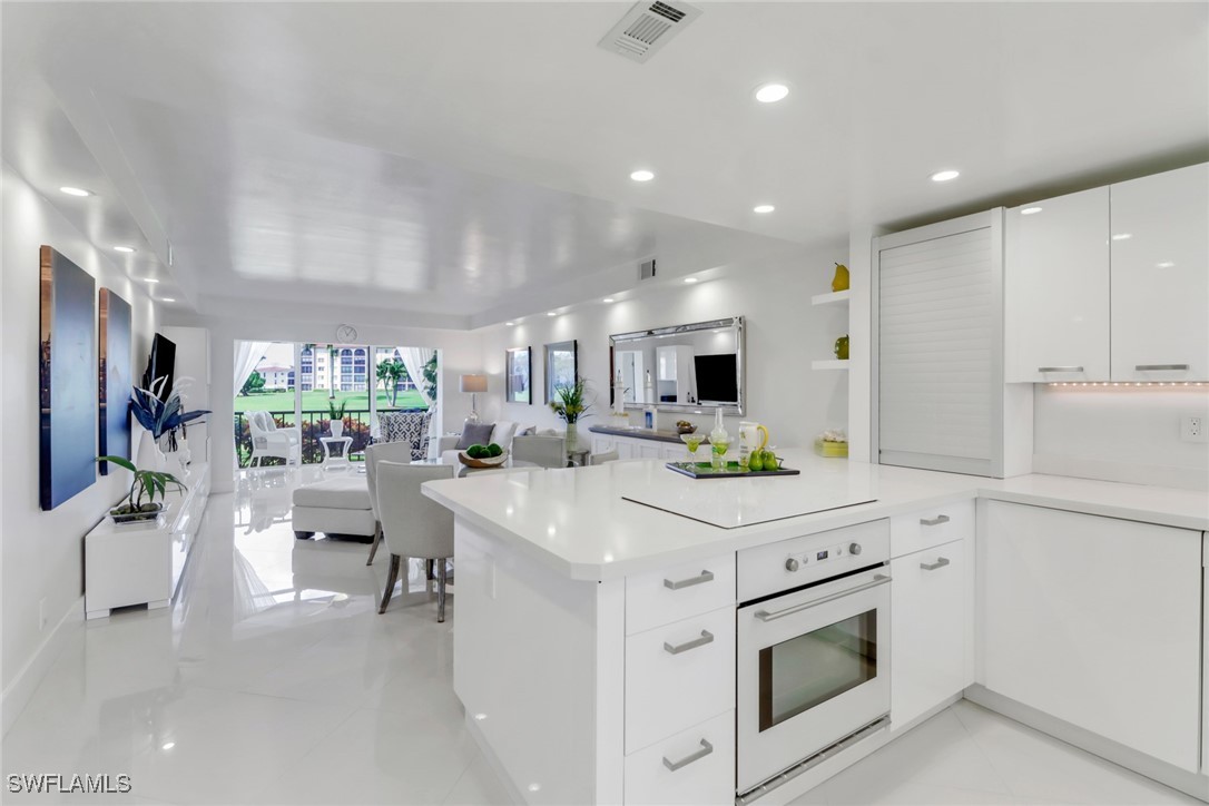 9 High Point Circle North, Unit 102 Naples, FL 34103 - Photo 6 of 48 a kitchen with a stove a refrigerator and a refrigerator