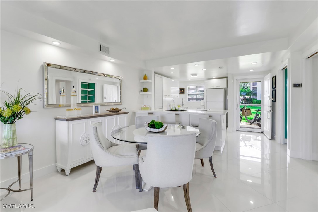 9 High Point Circle North, Unit 102 Naples, FL 34103 - Photo 7 of 48 a kitchen with dining table and chairs