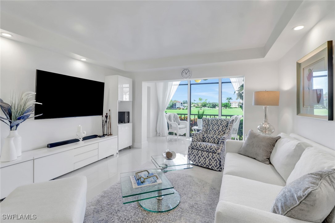 9 High Point Circle North, Unit 102 Naples, FL 34103 - Photo 8 of 48 a living room with furniture and a flat screen tv