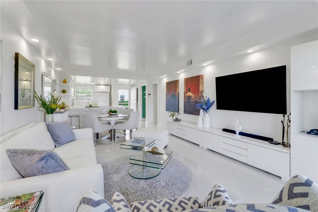 9 High Point Circle North, Unit 102 Naples, FL 34103 - Photo 9 of 48 a living room with furniture and a flat screen tv