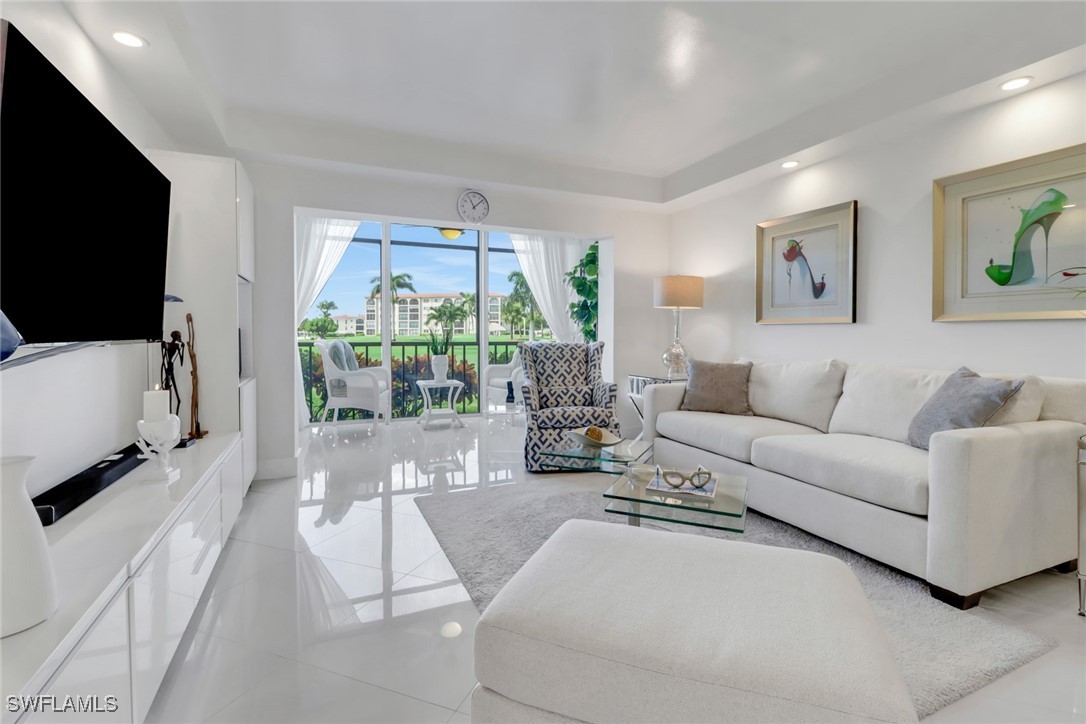 9 High Point Circle North, Unit 102 Naples, FL 34103 - Photo 10 of 48 a living room with furniture and a flat screen tv