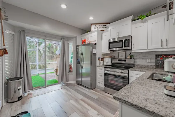 a kitchen with stainless steel appliances granite countertop a refrigerator a stove top oven a sink and dishwasher