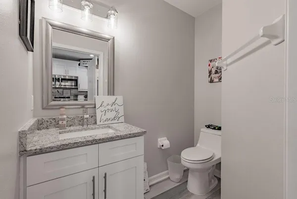 a bathroom with a granite countertop toilet sink and mirror