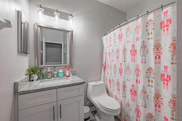 a bathroom with a granite countertop sink a toilet and a mirror