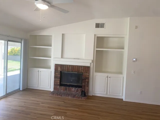 a view of a livingroom with a fireplace and wooden floor