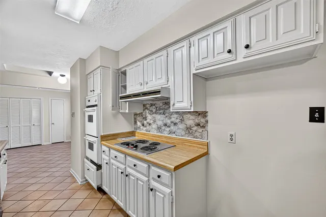 a kitchen with cabinets and a stove top oven