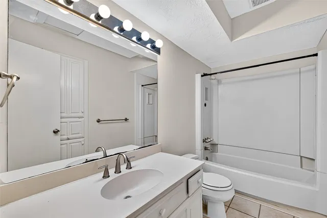 an empty room with wooden floor and a ceiling fan