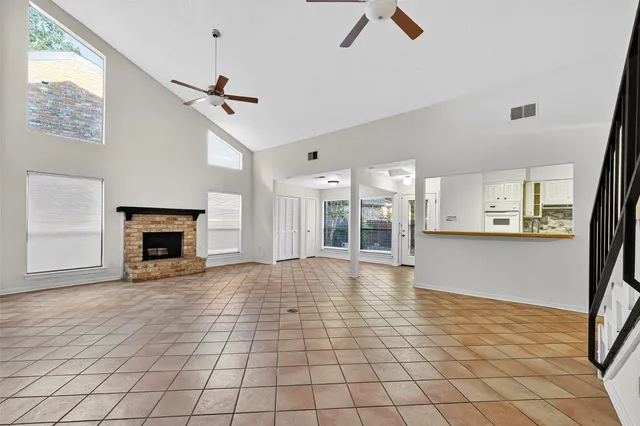 a view of an empty room with window and fireplace